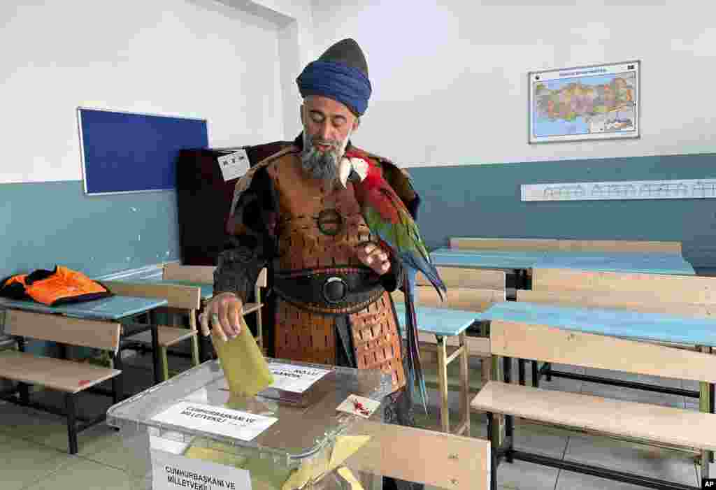 Назим Џихан (48) со својата птица гласа на избирачко место во Истанбул, Турција.