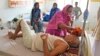 一名妇女在印度北方邦的一所医院里用湿布擦拭她生病的兄弟的头部，让他在热浪中保持凉爽。(2023年6月19日)