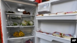 FILE - A Free Food Fridge Albany sidewalk refrigerator is stocked with produce and other food, June 25, 2021, in Albany, N.Y. The nonprofit Free-Go has put refrigerators and food storage centers in Geneva, Switzerland so people can get food. (AP Photo/Hans Pennink)