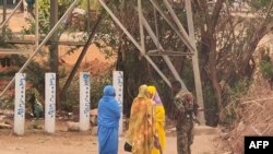 FILE - A soldier talks to women on a street in Khartoum on June 6, 2023, as fighting continues in war-torn Sudan.