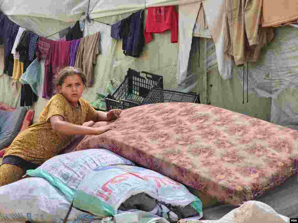 A girl rests after fleeing to the outskirts of Khan Younis, a city destroyed by war, overcrowded and without basic services, May 10, 2024. (VOA/Enas Tantesh) 