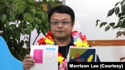 李孟居9月2日在台湾机场出示他四年前遭捕时，被中国海关视为谋反证据的小卡图样，包括为空服员打气的“爱与和平”小卡及“香港加油”小卡（美国之音特约记者李贤摄影）。