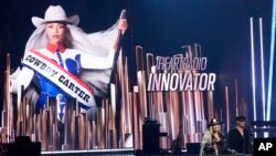Beyonce (kiri bawah), menerima Innovator Award saat presenter Stevie Wonder tampil di iHeartRadio Music Awards di Dolby Theater, Los Angeles, 1 April 2024. (AP/Chris Pizzallo)