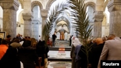 People attend a Palm Sunday Mass at the Grand Immaculate Church in Al-Hamdaniya, Iraq, April 2, 2023. 