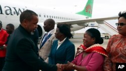 Malawi Vice President Saulos Chilima, left, greets government officials upon his return from South Korea in Lillongwe, June 9, 2024.