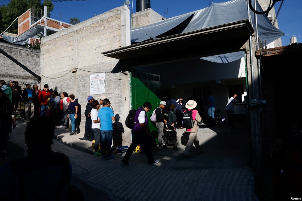 Desde tempranas horas el domingo, gente hace fila para votar en un centro electoral en la Ciudad de México.