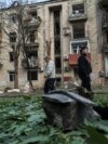 Local residents walk near an apartment building damaged by a Russian airstrike in Kharkiv, Ukraine, May 5, 2024.