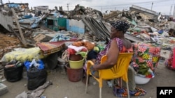 Une habitante expulsée tente de retrouver ses esprits après la démolition de sa maison dans le village d'Adjame, le 26 juillet 2024 à Abidjan. 