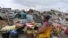 An evicted resident sits among her belongings after the demolition of her house in Adjame village in Abidjan, Ivory Coast.