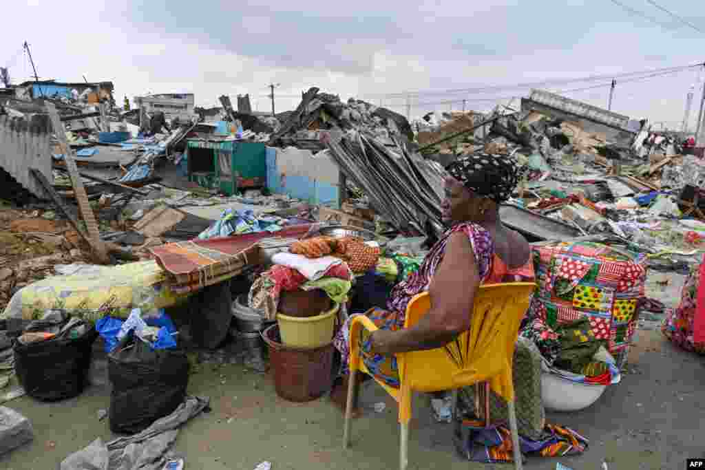 An evicted resident sits among her belongings after the demolition of her house in Adjame village in Abidjan, Ivory Coast.