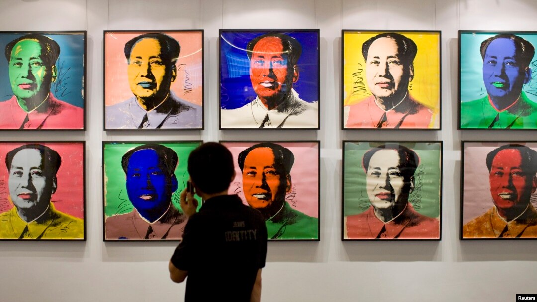 FILE - A visitor looks at a 10-piece set paper screenprint of Mao Zedong by Andy Warhol, which is part of Warhol's series of the late Chinese leader, displayed at the Hong Kong Convention and Exhibition Center, May 26, 2008. 