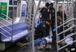 Polisi New York berusaha melakukan pertolongan pertama terhadap tunawisma Jordan Neely di kereta bawah tanah New York, namun jiwanya tidak tertolong, 1 Mei 2023.