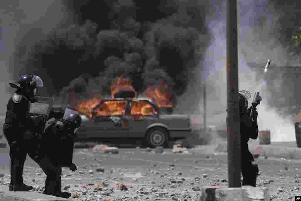 A riot police officer shoots tear gas at demonstrators during a protest at the Cheikh Anta Diop University campus in Dakar, Senegal.