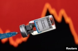 FILE - A vial of "VACCINE Coronavirus COVID-19" is seen in front of a stock graph in this illustration taken on January 17, 2022. (REUTERS/Dado Ruvic/Illustration)