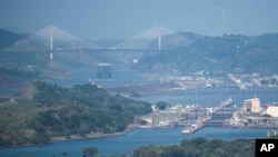 A cargo ship waits near the Centennial Bridge for transit through the Panama Canal locks, in Panama City, Wednesday, Jan. 17, 2024. (AP Photo/Agustin Herrera)