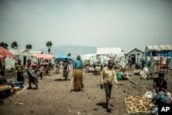 The 42-year-old mother of four who was raped walks in the Bulengo displacement camp, in Congo, Aug. 23, 2023.