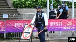 FILE - Police guard a checkpoint in the Wanchai district of Hong Kong on June 30, 2022. A top Chinese official said March 6, 2023, that Hong Kong must nip in the bud any potential threats to national security.