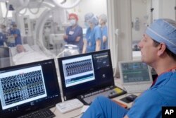 This photo shows Dr. Phillip Cuculich working with others to prepare for an experimental treatment using radiation for Jeff Backus' irregular heartbeat in St. Louis on Tuesday, Feb. 7, 2023. (Huy Mach/Washington University, St. Louis via AP)