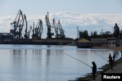 Local residents fish on an embankment, during the course of Russia-Ukraine conflict, in the Azov Sea port of Berdyansk, Zaporizhzhia region, Russian-controlled Ukraine, May 10, 2023.