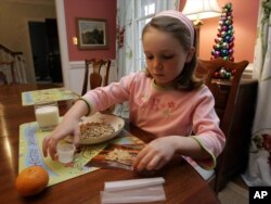 [FILE] Elizabeth White, 7 year-old with peanut allergies, mixes peanut powder with a fruit roll-up before taking her daily dosage.