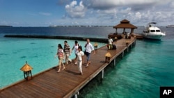 FILE - Foreign tourists arrive at a resort at Kurumba island, Maldives, Feb. 12, 2012. Responding to public anger over the Israel-Hamas war, the country, known for luxury resorts, will change its laws to prevent Israeli passport holders from visiting.