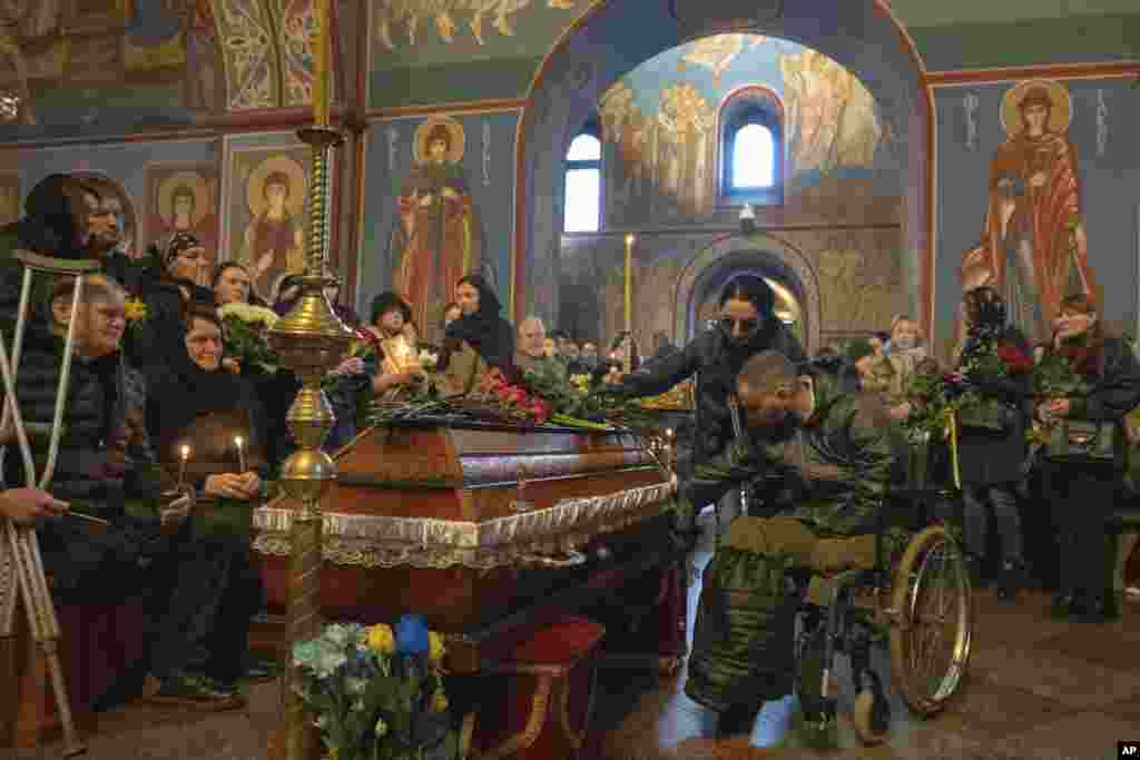 People pay their last respect to Ukrainian serviceman Oleksiy Sokolovskyi during the funeral ceremony in St. Michael Cathedral in Kyiv, Ukraine.