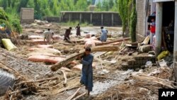 Afghan villagers clean debris after flash floods in Mohmand Dara district of Nangarhar province.