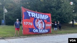 Dos simpatizantes del expresidente Donald Trump protestan con una bandera donde se lee "Trump o muerte" en inglés, frente a la cárcel del condado de Fulton, en Atlanta, Georgia, el 24 de agosto de 2023.