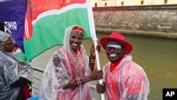 Trizah Atuka and Ferdinand Omanyala, flag bearers for Kenya, are seen on the team's boat as it makes its way along the Seine in Paris, France, during the opening ceremony for the 2024 Summer Olympics, July 26, 2024.