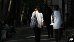 Iranian women walk in Tehran, Iran, Aug. 5, 2023. These days, with uncovered women a common sight on Tehran streets, authorities have begun raiding companies where women employees or customers have been seen without the headscarf, or hijab.