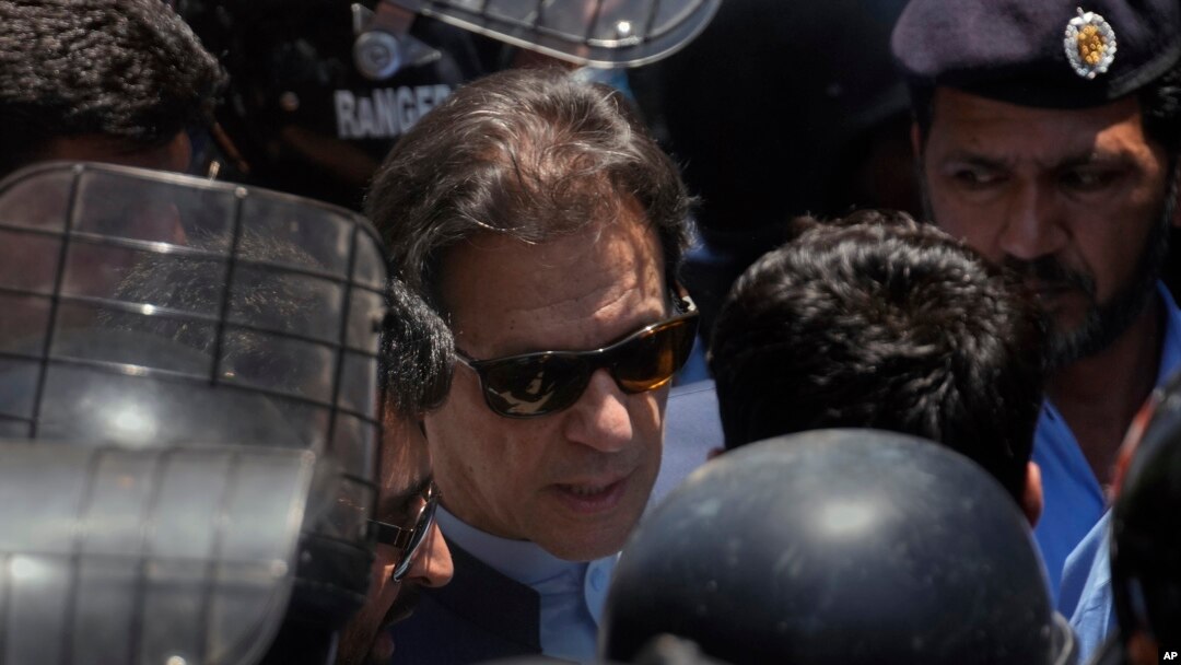 Mantan Perdana Menteri Pakistan Imran Khan, tengah, dikawal oleh petugas polisi saat dia tiba untuk menghadiri pengadilan, di Islamabad, Pakistan, Jumat, 12 Mei 2023. (AP/Anjum Naveed)