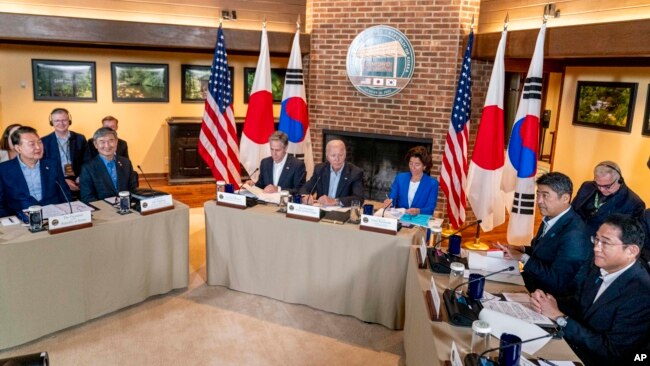 El presidente Joe Biden, en el centro, el primer ministro de Japón, Fumio Kishida, a la derecha, y el presidente de Corea del Sur, Yoon Suk Yeol, a la izquierda, se reúnen el 18 de agosto de 2023 en Camp David. Alrededor de Biden están el secretario de Estado Antony Blinken y la secretaria de Comercio Gina Raimondo.
