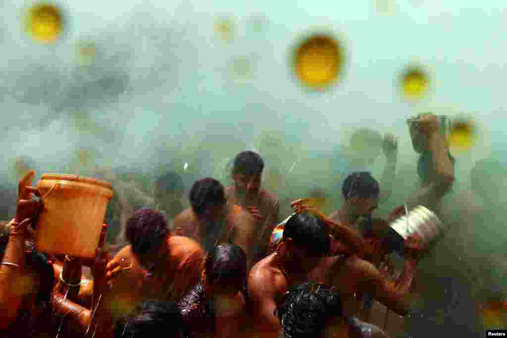 Umat ​​Hindu ambil bagian dalam &quot;Huranga&quot;, permainan yang dimainkan antara pria dan wanita sehari setelah festival warna &quot;Holi&quot;, di kuil Dauji dekat kota Mathura, India utara. (Reuters)&nbsp;