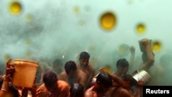Hindu devotees take part in Huranga, a game played between men and women a day after Holi, at Dauji temple near the northern city of Mathura, India.