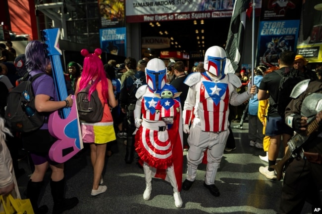 Para pengunjung mengenakan kostum Mandalorian Captain America berpose di acara New York Comic Con di Jacob K. Javits Convention Center, Jumat, 13 Oktober 2023, di New York. (Charles Sykes/Invision/AP)