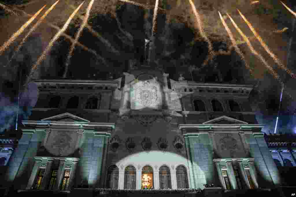  Los fuegos artificiales explotan sobre el Palacio Nacional mientras el presidente entrante de Guatemala, Bernardo Arévalo, y la vicepresidenta Karin Herrera saludan a sus partidarios desde el balcón, el día de su toma de posesión en la Ciudad de Guatemala, en la madrugada del 15 de enero de 2024. (Foto AP/Santiago Billy) &nbsp; 