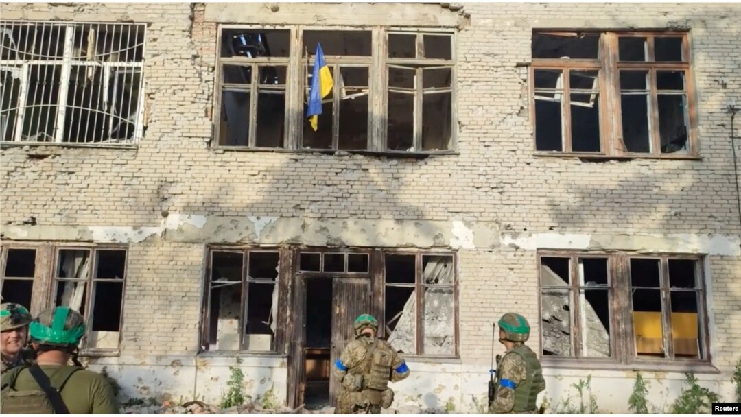 Tentara Ukraina berdiri di bawah bendera Ukraina di Wilayah Donetsk, Ukraina, 11 Juni 2023. (Foto: via Reuters)