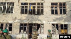 Tentara Ukraina berdiri di bawah bendera Ukraina di Wilayah Donetsk, Ukraina, 11 Juni 2023. (Foto: via Reuters)