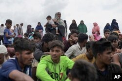 Pengungsi Rohingya beristirahat di pantai Lampanah Leungah setelah mendarat di Aceh Besar, Provinsi Aceh, Kamis, 16 Februari 2023. (AP/Riska Munawarah)