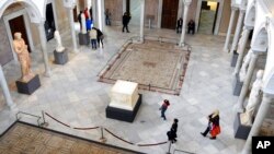 FILE - Tunisians stroll in Tunisia's National Bardo Museum Monday, March 30, 2015. 