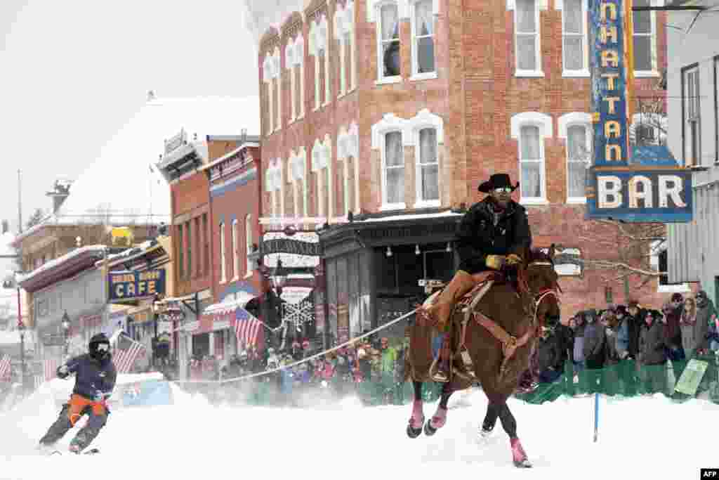 A rider pulls a skier down Harrison Avenue during the 76th annual Leadville Ski Joring weekend competition, March 3, 2024 in Leadville, Colorado. 