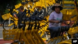 Workers unload bicycles from a bike-share service in Beijing, Aug. 15, 2023. China’s youth unemployment rate has hit record highs every month since April, reaching 21.3% in June, when authorities decided to halt the release of age-related job data.