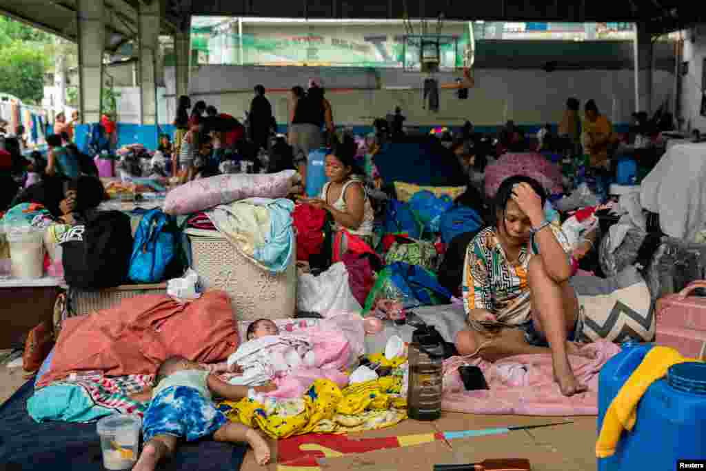 People take shelter at a basketball court temporarily converted into an evacuation center following the floods brought by Typhoon Gaemi, in San Mateo town, Rizal province, Philippines, July 25, 2024.