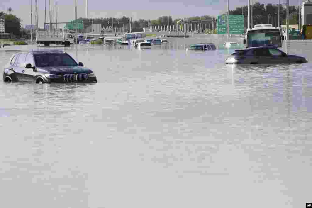 Kendaraan-kendaraan terbengkalai di tengah banjir yang menutupi jalan utama di kota Dubai, Uni Emirat Arab akibat hujan lebat di negara kota gurun tersebut. (AP)&nbsp;