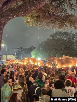 Flambeaux carriers lead a 2023 Carnival season parade. As early as 1857, enslaved Black men and free men of color lit the way with torches, a tradition that lives on as Black New Orleanians pay homage to torch carriers from the past.