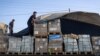 A man unloads humanitarian aid on a convoy of lorries entering the Gaza Strip from Egypt via the Rafah border crossing, Oct. 21, 2023. 