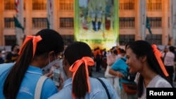 Move Forward Party supporters, in orange ribbons to celebrate the party, share details of election results in Bangkok, May 15, 2023.