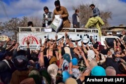 FILE - People crowd each other to buy subsidized sacks of wheat flour in Quetta, Pakistan, Thursday, Jan. 12, 2023, after a recent price increase of flour in the country. (AP Photo/Arshad Butt, File)