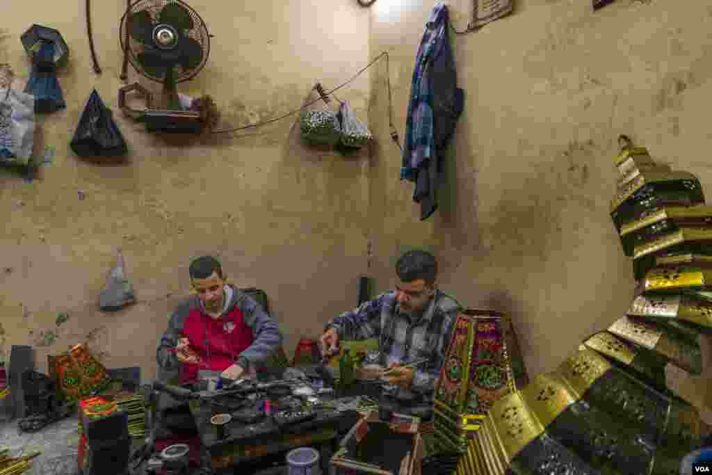 Nasser Banha and Mostafa Nasser, father and son, handcraft traditional Ramadan lanterns in their small workshop inside their apartment building. (Hamada Elrasam/VOA)