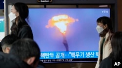 A North Korean missile launch is shown during a TV news program at the Seoul Railway Station in Seoul, South Korea, March 28, 2023. North Korea on Tuesday unveiled smaller nuclear warheads, state media said.